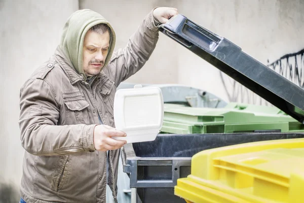 Sin hogar cerca de contenedor de basura con caja de comida abierta —  Fotos de Stock