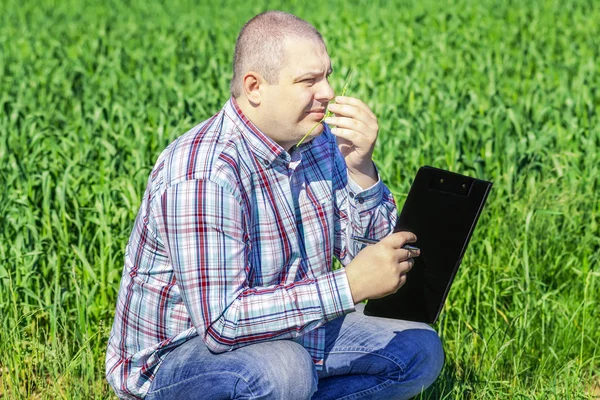 Farmer with folder near the cereal field — Stock Photo, Image