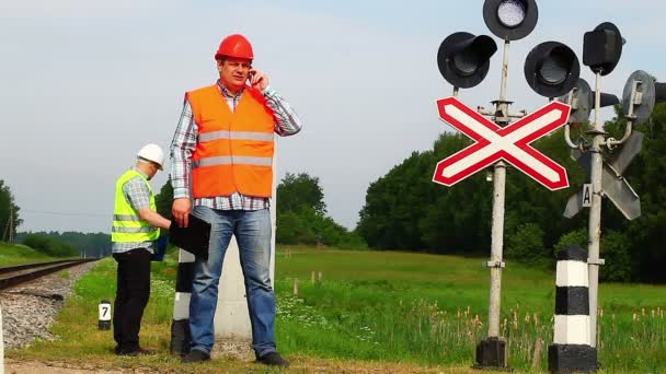 Spoorweg werknemer met mobiele telefoon — Stockvideo