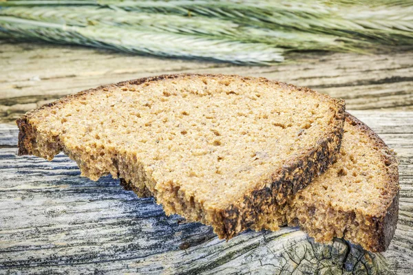 Bread with ears on a old wooden background — Stock Photo, Image