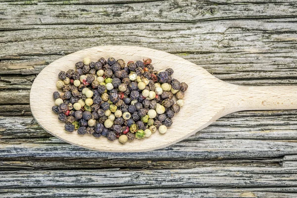 Varias mezclas de pimienta sobre un fondo de madera viejo — Foto de Stock