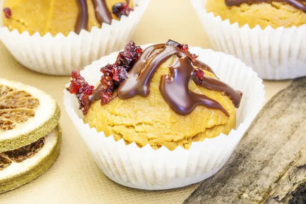 Cupcakes with cranberries on a sheet of baking paper — Stock Photo, Image
