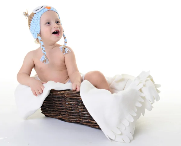 bir sepet içinde oturan şapkalı çocuk