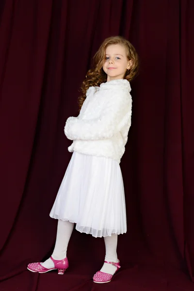 güzel kız beyaz elbise ve bir kürk kırmızı bir arka plan üzerinde