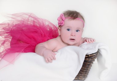 beyaz zemin üzerinde bir sepet içinde küçük kız