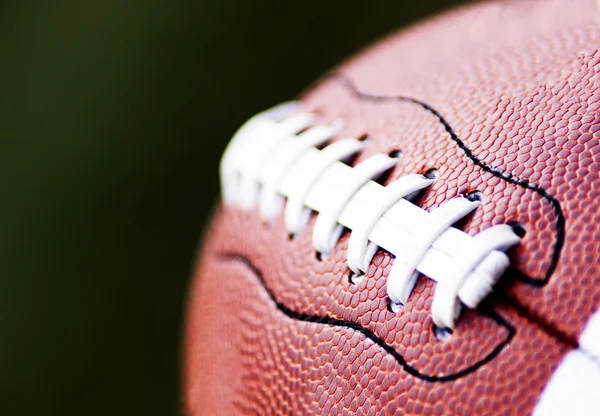 Close up of an american football against a black background — Stock Photo, Image