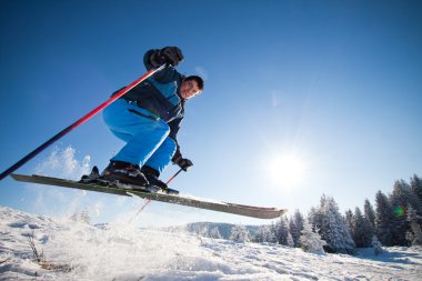 Güneşli günde ekstrem kayak yapan bir adam.