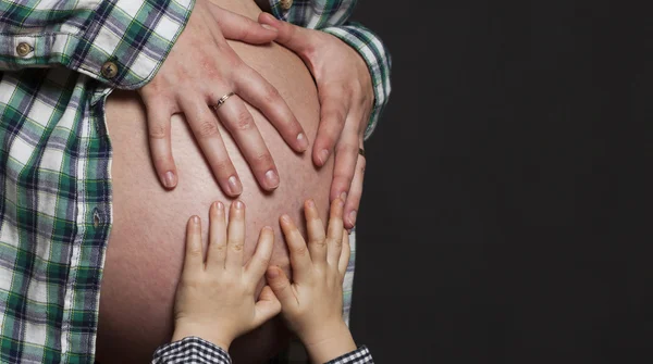 Hands of child on belly of pregnant woman — Stock Photo, Image