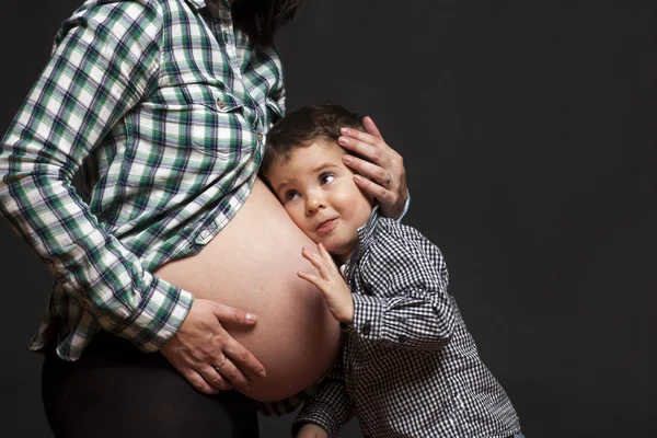 Young boy is listening to his new brother or sister — Stock Photo, Image