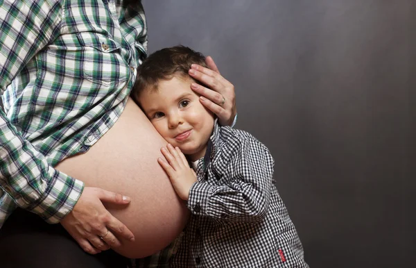 Young boy is listening to his new brother or sister Royalty Free Stock Photos