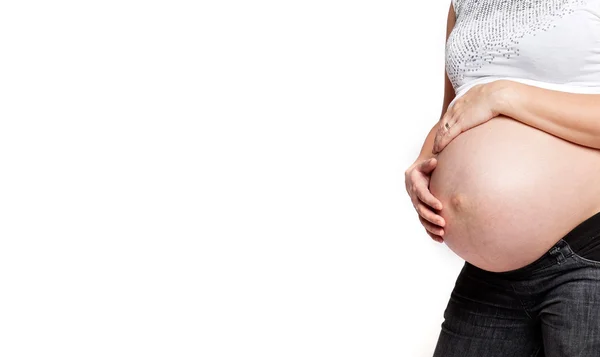 Mage těhotné ženy dotýkal její břicho rukama — Stock fotografie