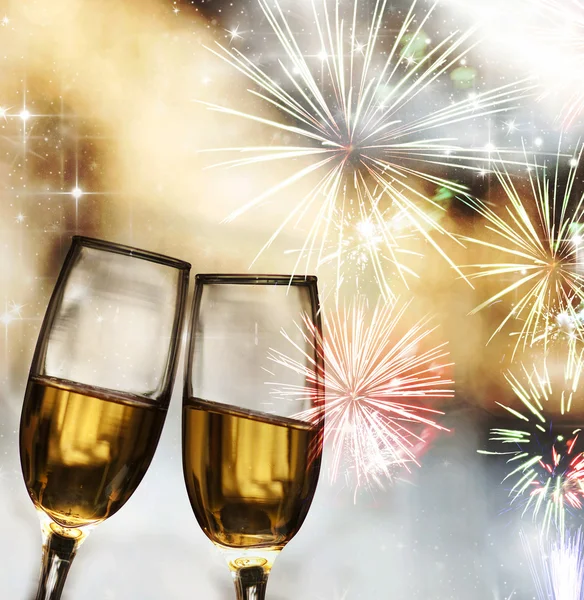 Bicchieri con champagne contro fuochi d'artificio — Foto Stock