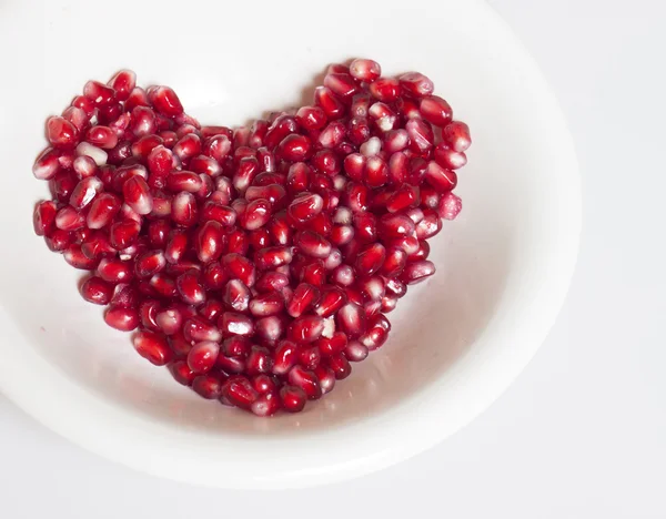 Heart shaped pomegranate seeds — Stock Photo, Image