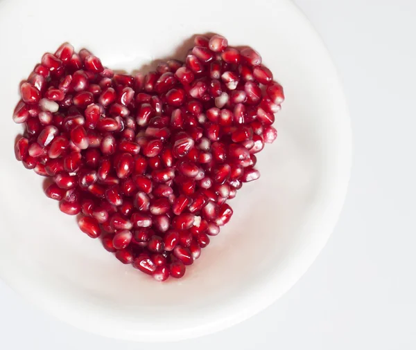 Heart shaped pomegranate seeds — Stock Photo, Image