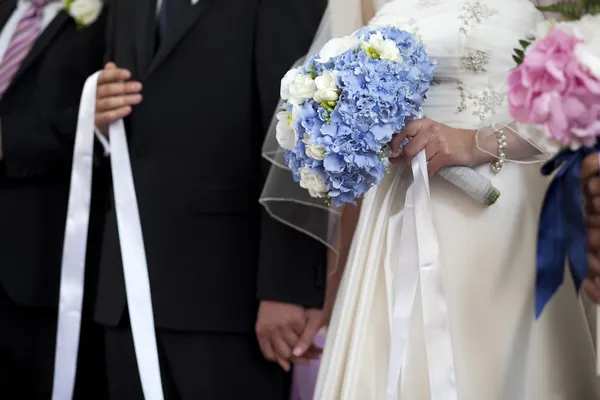 Vintage photo of bride and groom's hands holding wedding bouquet — Stock Photo, Image