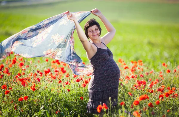 Young pregnant woman in poppy field — Stock Photo, Image