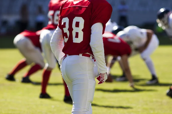 American football game with out of focus players in the background — Stock Photo, Image