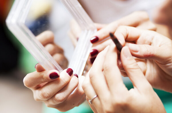 Two women hands holding a mirror