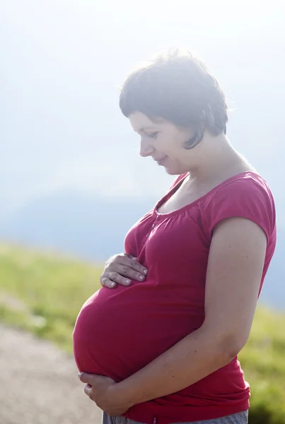 Gravida femeie fericită într-un câmp în aer liber — Fotografie, imagine de stoc