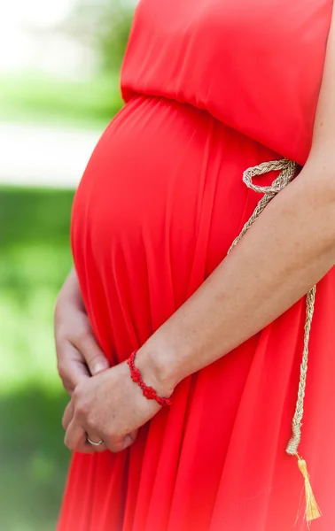 Pregnant bride in red dress — Stock Photo, Image