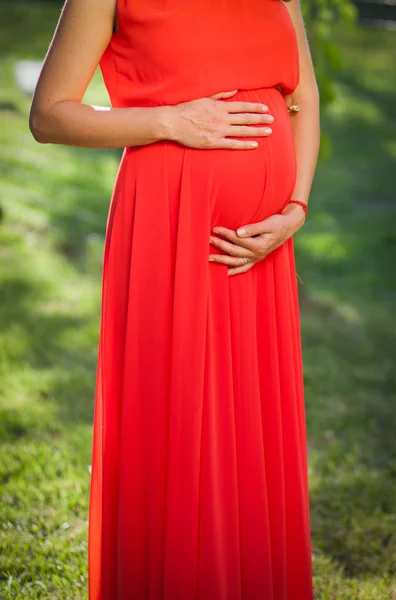 Pregnant bride in red dress — Stock Photo, Image