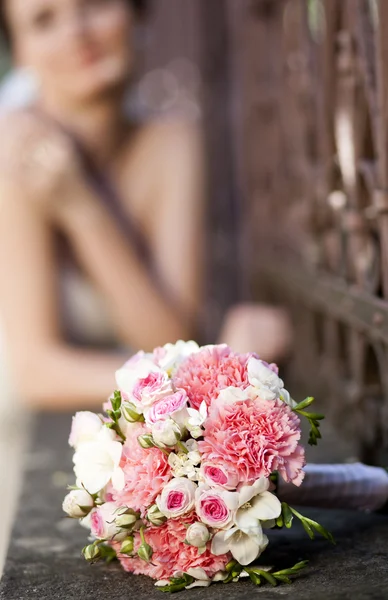 Beautiful white and pink wedding bouquet with bride in the background — Stock Photo, Image