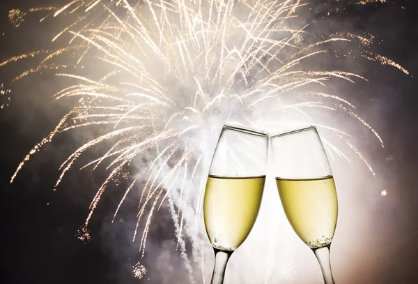 Bicchieri con champagne contro fuochi d'artificio — Foto Stock