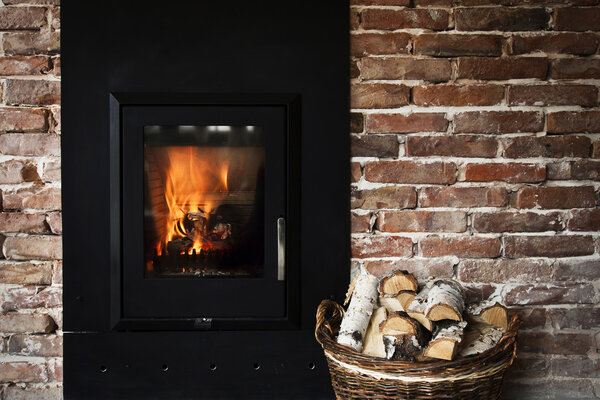 Fireplace in a brick wall and woods in basket