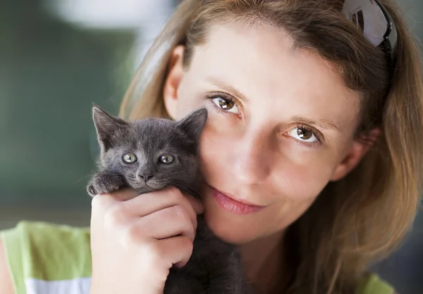 Woman holding cute black kitten — Stock Photo, Image
