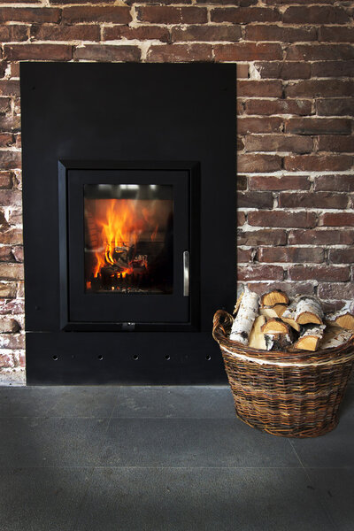 Fireplace in a brick wall and woods in basket