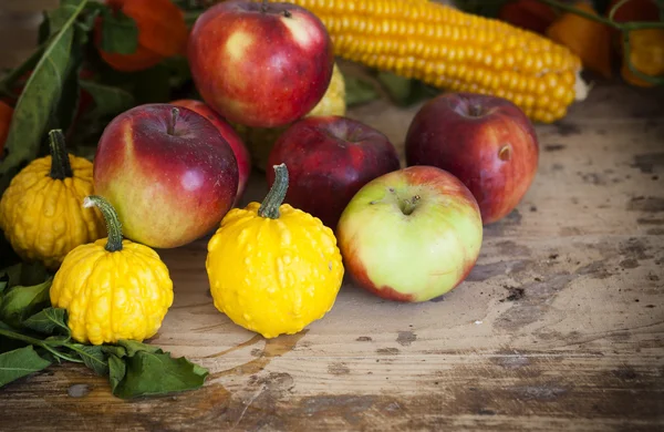 Calabazas, manzanas, maíz y physalis sobre mesa de madera —  Fotos de Stock