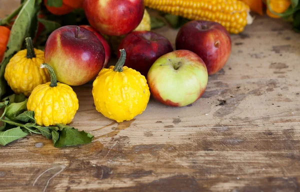 Гарбузи, яблука, кукурудза та фізикалізм на дерев'яному столі — стокове фото