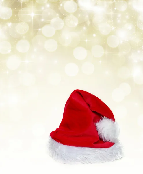 Weihnachtsmann-Hut auf goldenem Hintergrund — Stockfoto