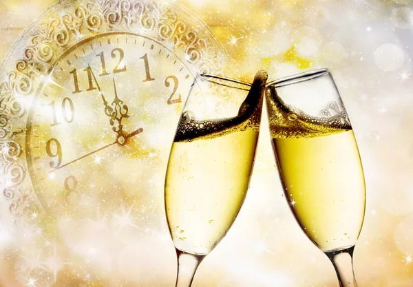 Gläser mit Champagner und Uhr kurz vor Mitternacht — Stockfoto