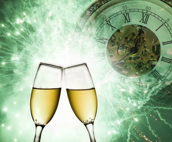 Champagne glasses, clock and fireworks at midnight — Stock Photo, Image