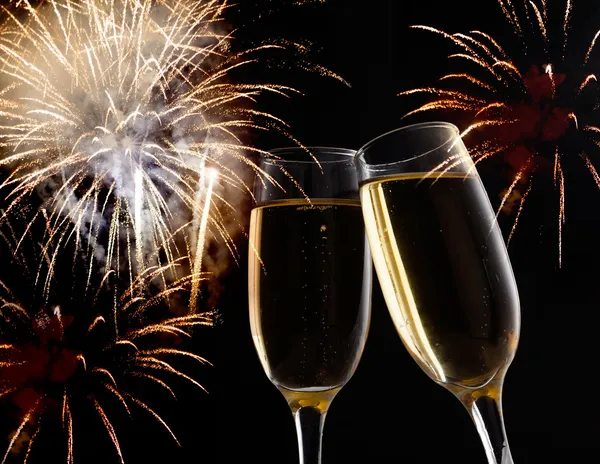 Bicchieri con champagne contro fuochi d'artificio — Foto Stock