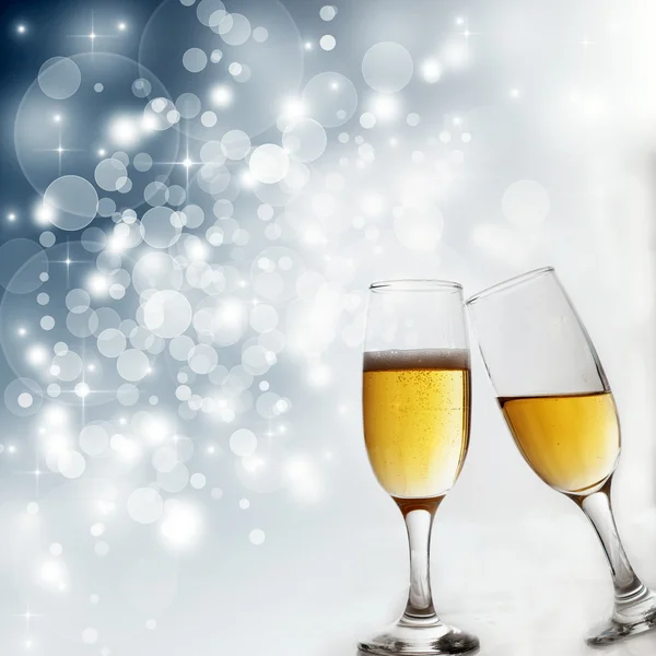 Bicchieri con champagne contro le luci delle vacanze — Foto Stock