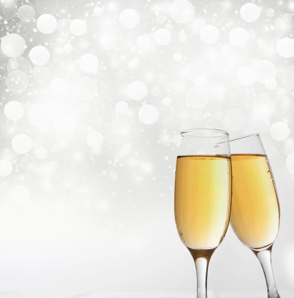 Glasses with champagne against holiday lights — Stock Photo, Image