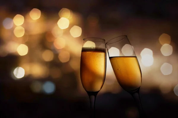 Glasses with champagne against fireworks — Stock Photo, Image