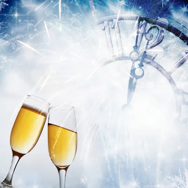 Glasses with champagne against fireworks and clock close to midnight — Stock Photo, Image