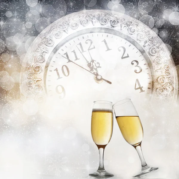 Glasses with champagne against fireworks and clock close to midnight — Stock Photo, Image