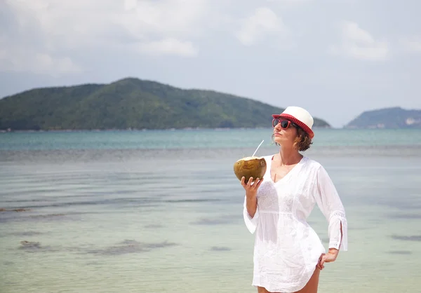 Frau mit Kokosnuss am Strand — Stockfoto