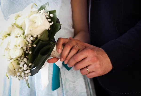 Händer och ringar på bröllopsbukett — Stockfoto