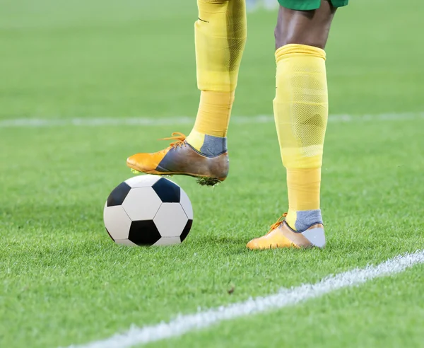 Soccer player's leg on ball — Stock Photo, Image