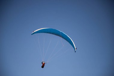 Mavi gökyüzüne karşı yamaç paraşütü Uçan adrenalin ve özgürlük konsepti