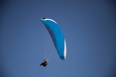 Mavi gökyüzüne karşı yamaç paraşütü Uçan adrenalin ve özgürlük konsepti