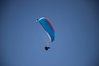 Mavi gökyüzüne karşı yamaç paraşütü Uçan adrenalin ve özgürlük konsepti