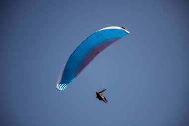 Mavi gökyüzüne karşı yamaç paraşütü Uçan adrenalin ve özgürlük konsepti