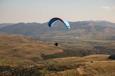 Mavi gökyüzüne karşı yamaç paraşütü Uçan adrenalin ve özgürlük konsepti