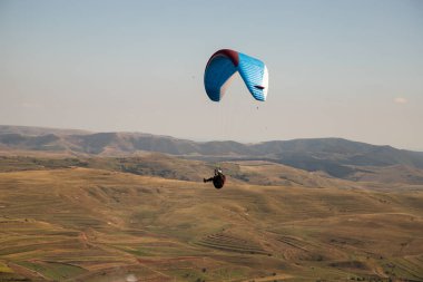 Mavi gökyüzüne karşı yamaç paraşütü Uçan adrenalin ve özgürlük konsepti